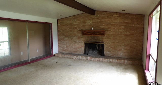 915 John St, Jacksonville, TX 75766 - unfurnished living room with healthy amount of natural light, carpet flooring, and a brick fireplace