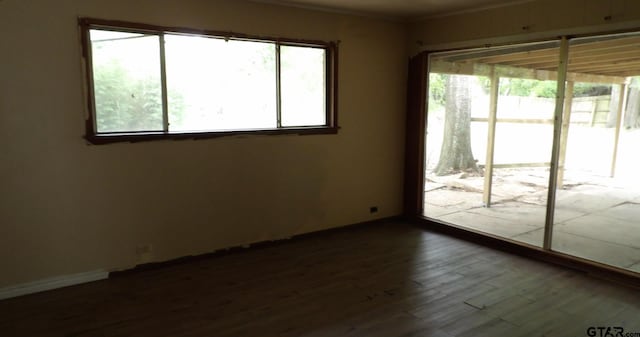 915 John St, Jacksonville, TX 75766 - spare room featuring healthy amount of natural light, dark wood-type flooring, and crown molding