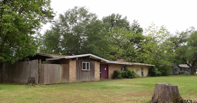915 John St, Jacksonville, TX 75766 - view of home's exterior featuring a yard and a chimney