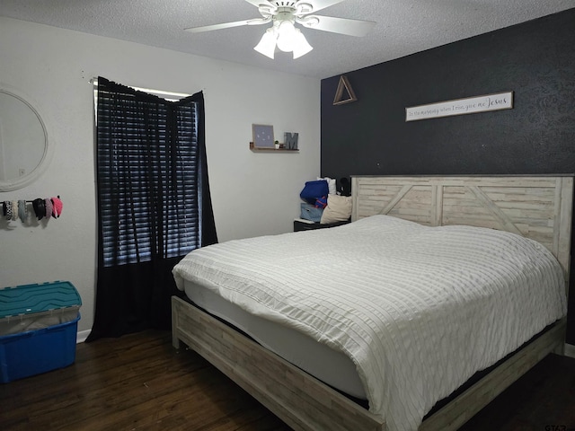 bedroom with ceiling fan, wood finished floors, and a textured ceiling