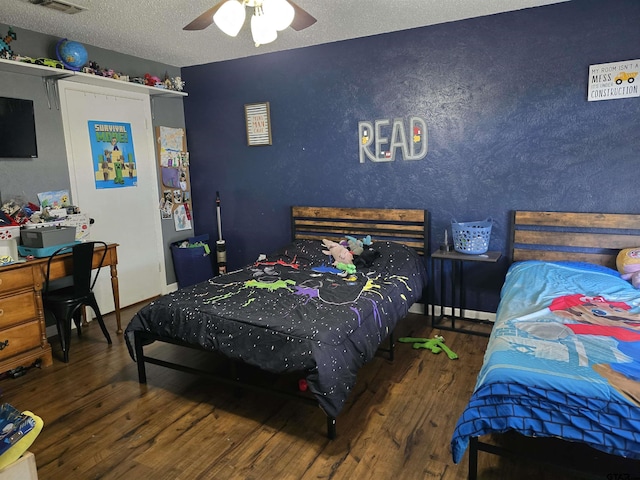 bedroom featuring visible vents, baseboards, ceiling fan, a textured ceiling, and wood finished floors