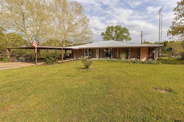 view of front of house with an attached carport, a front yard, and metal roof
