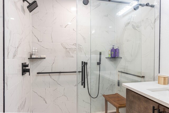 bathroom with a marble finish shower and vanity