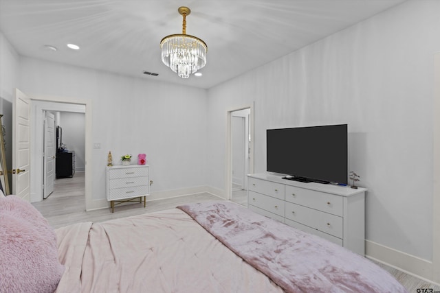 bedroom featuring light hardwood / wood-style floors and a notable chandelier