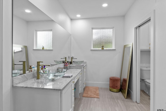 bathroom with vanity, a healthy amount of sunlight, and toilet