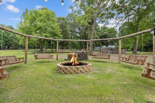 exterior space featuring a fire pit and a lawn