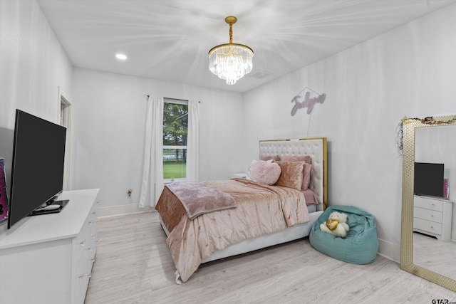 bedroom featuring light hardwood / wood-style floors and a chandelier