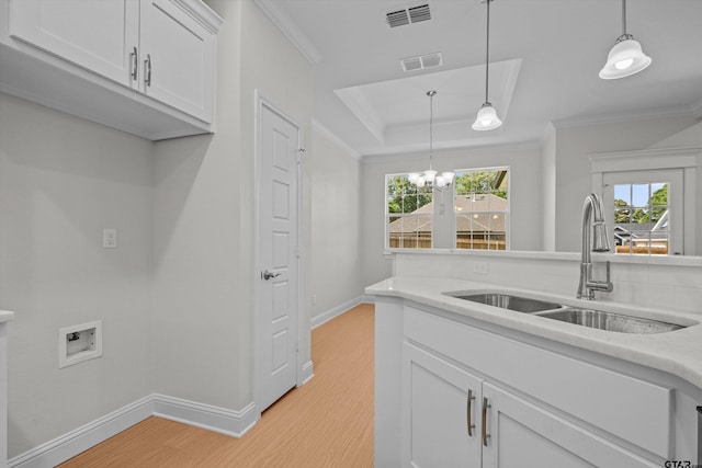 kitchen featuring light hardwood / wood-style floors, white cabinetry, sink, light stone countertops, and decorative light fixtures