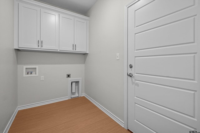 clothes washing area featuring cabinets, washer hookup, electric dryer hookup, and light hardwood / wood-style flooring