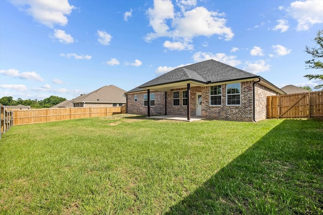 back of property with a lawn and a patio area