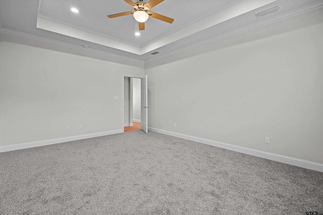 carpeted spare room featuring ceiling fan, a raised ceiling, and crown molding