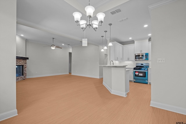 kitchen featuring ornamental molding, stainless steel appliances, white cabinetry, hanging light fixtures, and light hardwood / wood-style floors