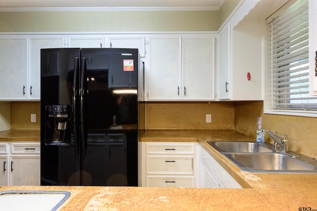 kitchen featuring sink, white cabinetry, and black fridge with ice dispenser