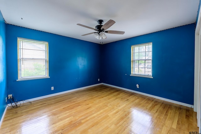 spare room with hardwood / wood-style flooring, a healthy amount of sunlight, and ceiling fan