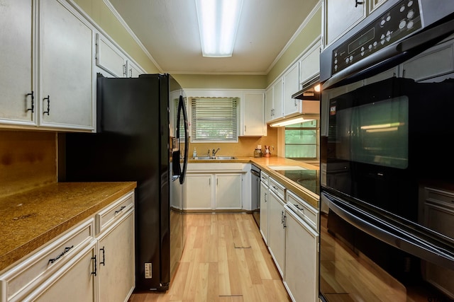 kitchen featuring black appliances, crown molding, white cabinetry, sink, and light hardwood / wood-style flooring