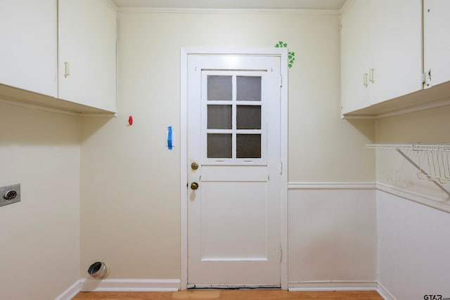 laundry area featuring ornamental molding, hookup for an electric dryer, and cabinets