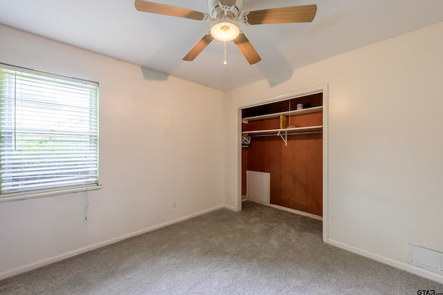 unfurnished bedroom with ceiling fan, multiple windows, a closet, and carpet flooring