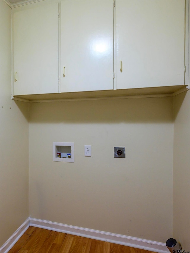 laundry room with washer hookup, electric dryer hookup, light hardwood / wood-style flooring, and cabinets