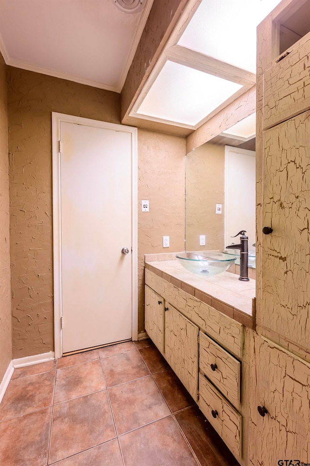 bathroom featuring crown molding, tile patterned flooring, and vanity