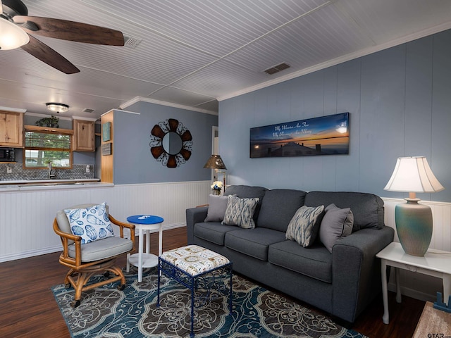 1915 Big Eddy Cir, Chandler, TX 75758 - living room featuring wood finished floors, a ceiling fan, crown molding, and a wainscoted wall