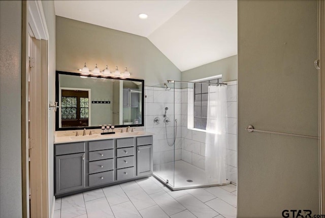 bathroom featuring vanity, a tile shower, and vaulted ceiling