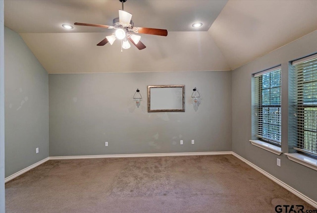 carpeted spare room with vaulted ceiling and ceiling fan