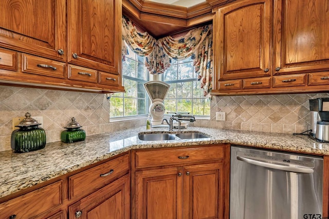 kitchen with light stone countertops, sink, dishwasher, and tasteful backsplash