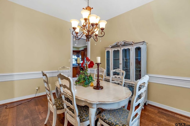 dining space with dark hardwood / wood-style flooring and a chandelier