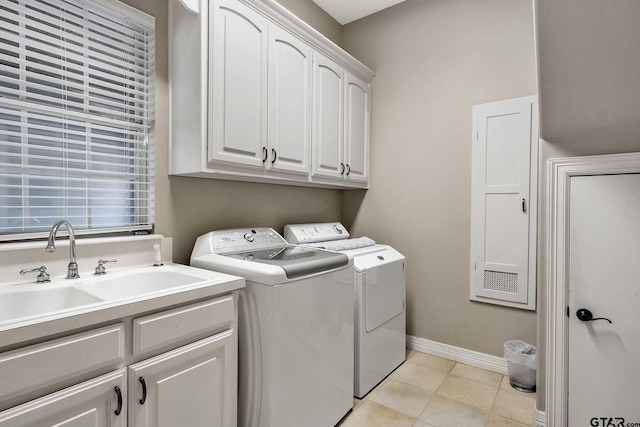 laundry area featuring washer and clothes dryer, cabinets, sink, and light tile patterned flooring