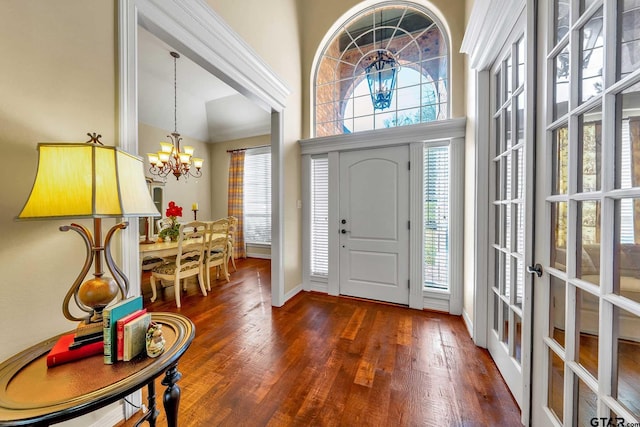 entrance foyer featuring dark wood-type flooring, an inviting chandelier, french doors, and a towering ceiling