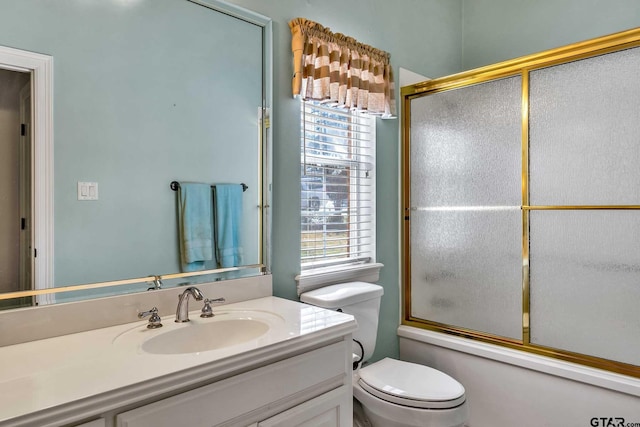 full bathroom with vanity, combined bath / shower with glass door, and toilet