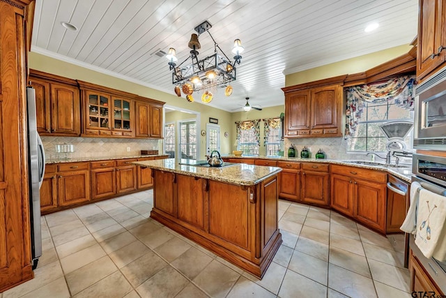 kitchen featuring a kitchen island, a wealth of natural light, appliances with stainless steel finishes, and hanging light fixtures