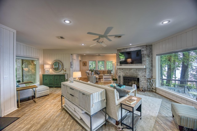 17553 Sleepy Hollow Way, Flint, TX 75762 - living area featuring a stone fireplace, ceiling fan, light wood-type flooring, wood walls, and recessed lighting