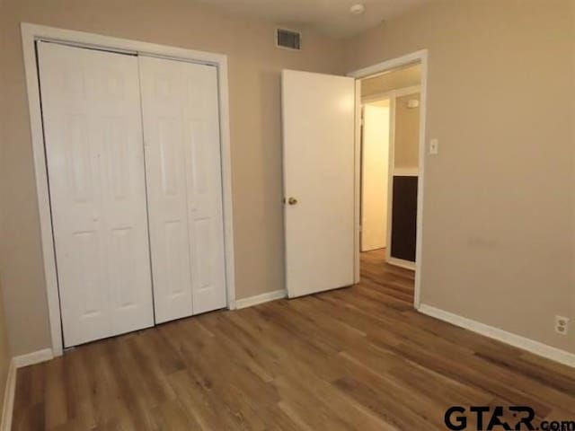 510EMMAST W Emma St, Bullard, TX 75757 - unfurnished bedroom featuring wood finished floors, baseboards, a closet, and visible vents