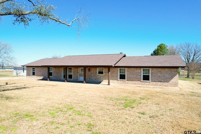 rear view of house with a patio area and a lawn