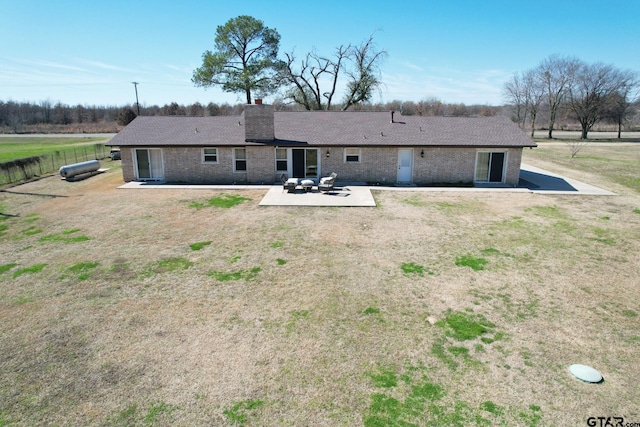 back of property with a patio area and a lawn