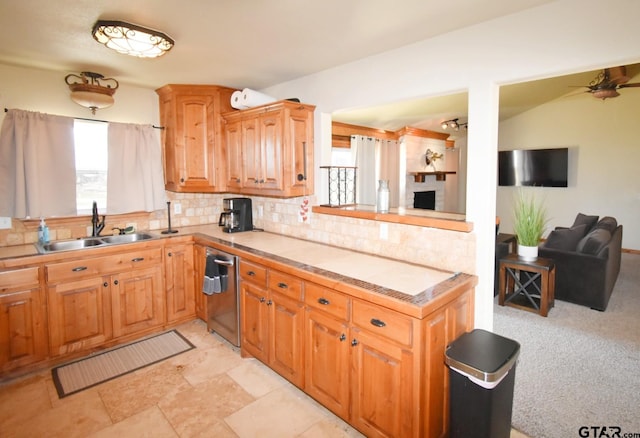 kitchen featuring ceiling fan, dishwasher, sink, and decorative backsplash