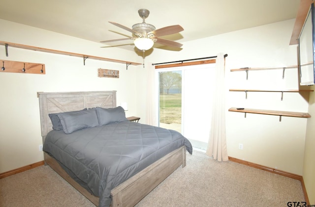 carpeted bedroom with ceiling fan and a barn door