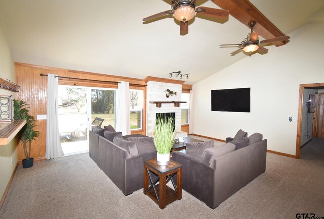 living room featuring high vaulted ceiling, a fireplace, carpet flooring, ceiling fan, and beam ceiling