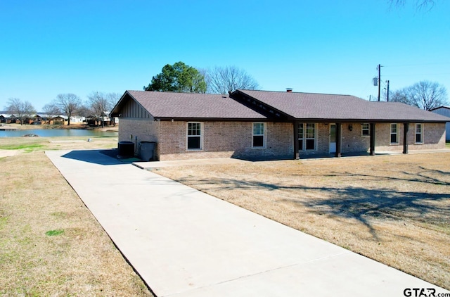 single story home featuring a water view, a front yard, and central air condition unit