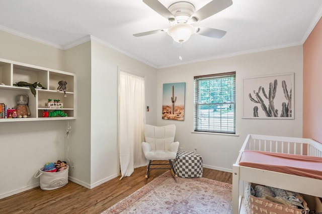 bedroom with wood finished floors, crown molding, baseboards, and a ceiling fan