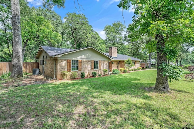 ranch-style house featuring a chimney, brick siding, and central air condition unit