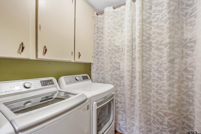 clothes washing area featuring independent washer and dryer and cabinet space