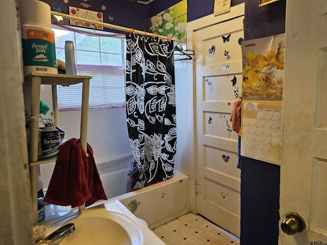 bathroom featuring shower / bath combo with shower curtain and a sink
