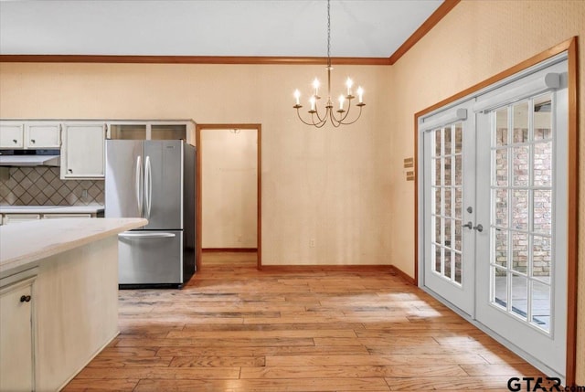23424BAYSIDE Bay Side Dr, Bullard, TX 75757 - unfurnished dining area featuring light wood finished floors, a chandelier, ornamental molding, and french doors