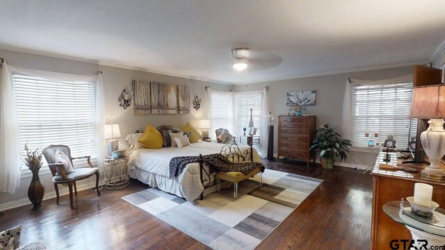 bedroom with ornamental molding, multiple windows, baseboards, and wood finished floors