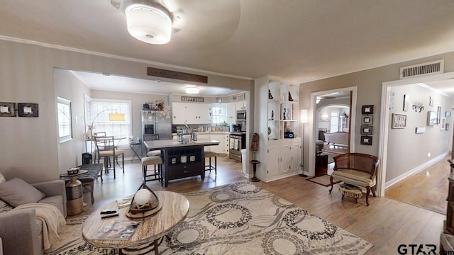 living room with light wood-type flooring, baseboards, and arched walkways