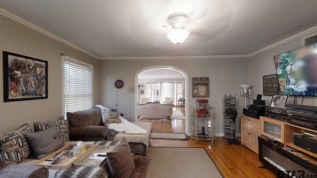 living room with arched walkways, light wood-type flooring, ornamental molding, and baseboards