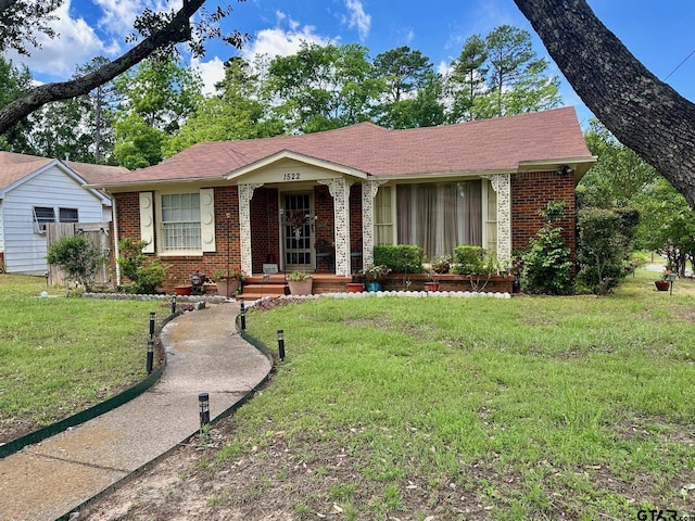 view of front of home featuring brick siding, covered porch, and a front lawn