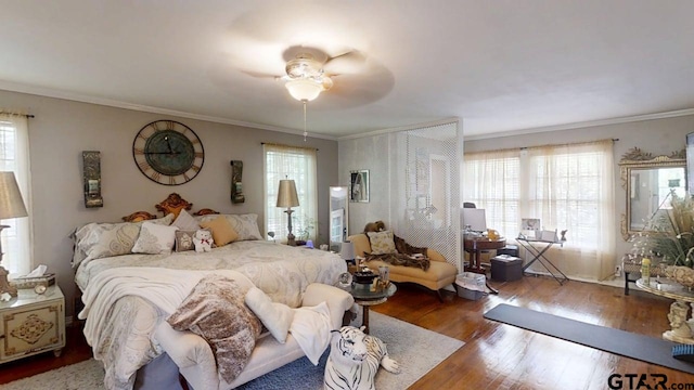 bedroom featuring wood finished floors, multiple windows, ornamental molding, and ceiling fan